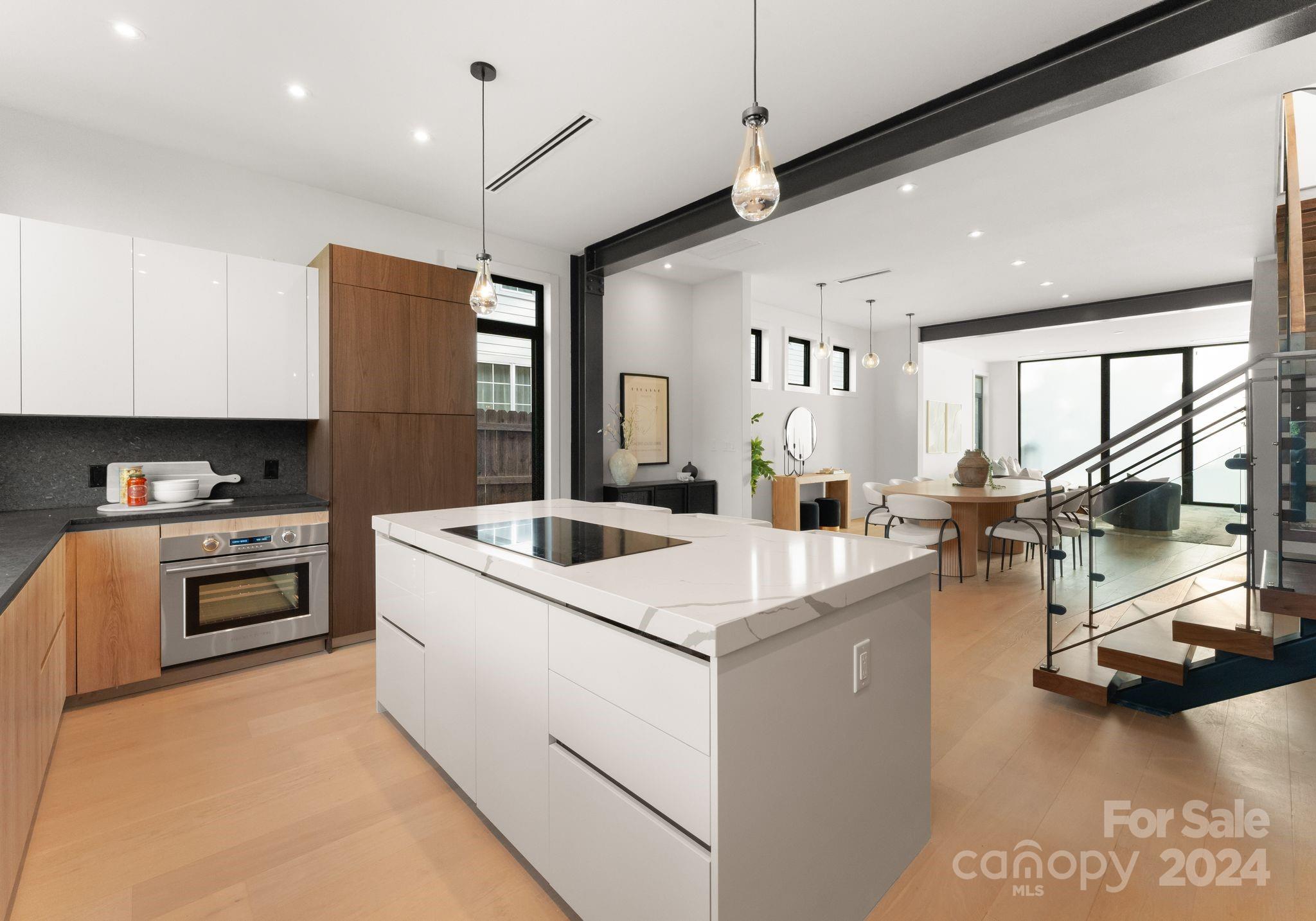 237 Marsh Road, Unit 101 Charlotte, NC 28209 - Photo 40 of 48 a kitchen with a stove a refrigerator a sink dishwasher a oven with a dining table and chairs with wooden floor