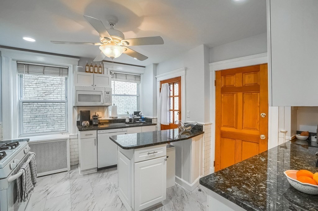 22 James Street, Unit 1 Brookline, MA 02446 - Photo 6 of 24 a kitchen with stainless steel appliances granite countertop a sink stove and refrigerator