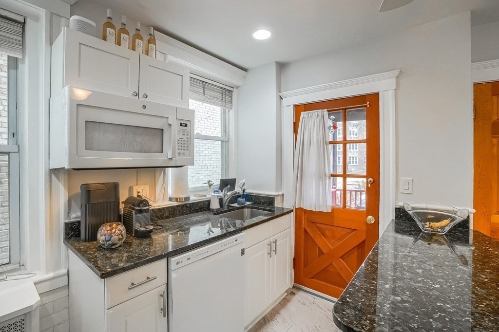 22 James Street, Unit 1 Brookline, MA 02446 - Photo 9 of 24 a kitchen with stainless steel appliances granite countertop a sink a stove and a microwave