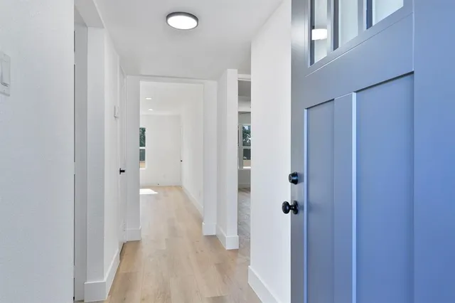 a view of a hallway with wooden floor and closet area