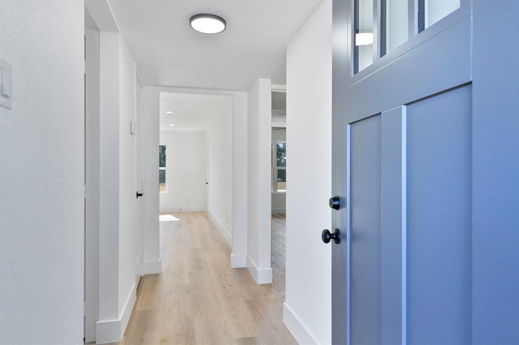 a view of a hallway with wooden floor and closet area
