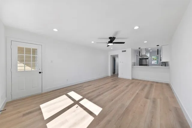 a view of empty room with wooden floor and windows