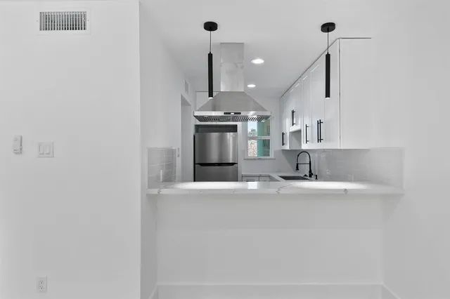 a view of a kitchen with a sink and a refrigerator