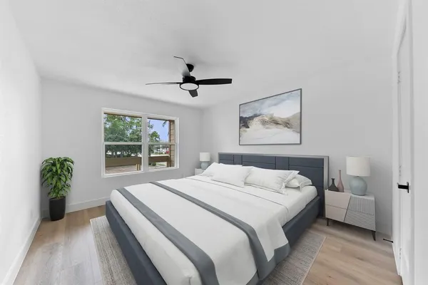 a bedroom with a large bed and a chandelier