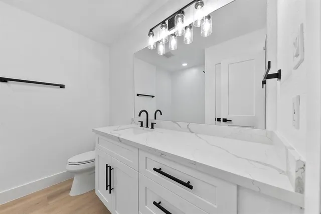 a view of bathroom with a sink a toilet and a mirror