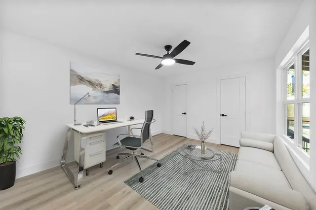 a living room with furniture a window and a potted plant