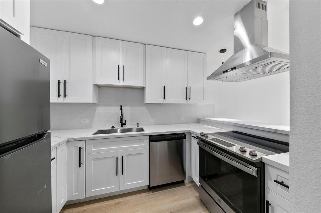 1514 Wirt Road, Unit 4 Houston, TX 77055 - Photo 6 of 20 a kitchen with white cabinets stainless steel appliances and sink