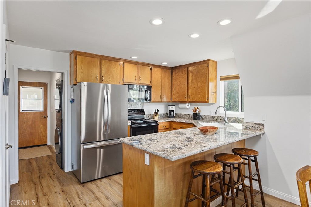 28207 Oaks Rancho Road Keene, CA 93531 - Photo 15 of 48 a kitchen with stainless steel appliances granite countertop a refrigerator a stove a sink a oven a dining table and chairs with wooden floor