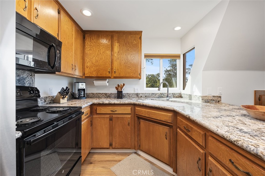 28207 Oaks Rancho Road Keene, CA 93531 - Photo 17 of 48 a kitchen with granite countertop stainless steel appliances a sink stove and cabinets