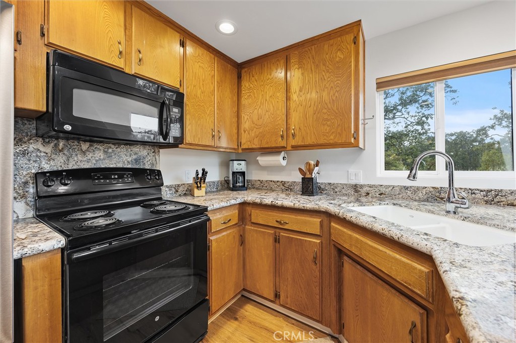 28207 Oaks Rancho Road Keene, CA 93531 - Photo 18 of 48 a kitchen with granite countertop a stove sink and microwave
