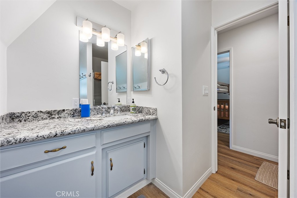 28207 Oaks Rancho Road Keene, CA 93531 - Photo 30 of 48 a bathroom with a granite countertop sink and a mirror