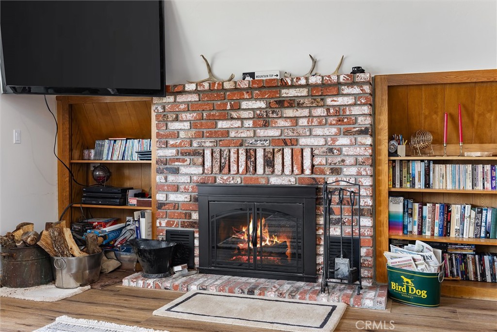 28207 Oaks Rancho Road Keene, CA 93531 - Photo 9 of 48 a living room with furniture a bookshelf and a fireplace