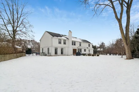 a front view of a house with a yard covered in snow