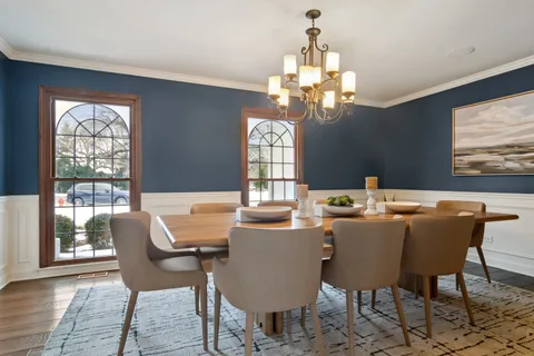a dining room with furniture a chandelier and window