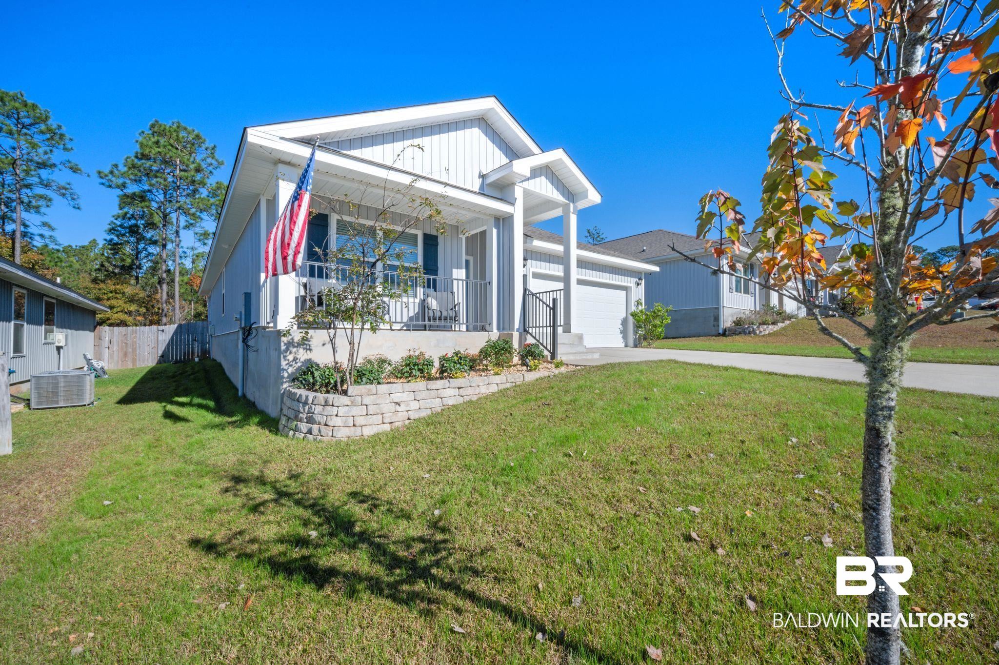 10306 Brodick Loop Spanish Fort, AL 36527 - Photo 30 of 35 View of front facade featuring a garage, covered porch, central air condition unit, and a front lawn