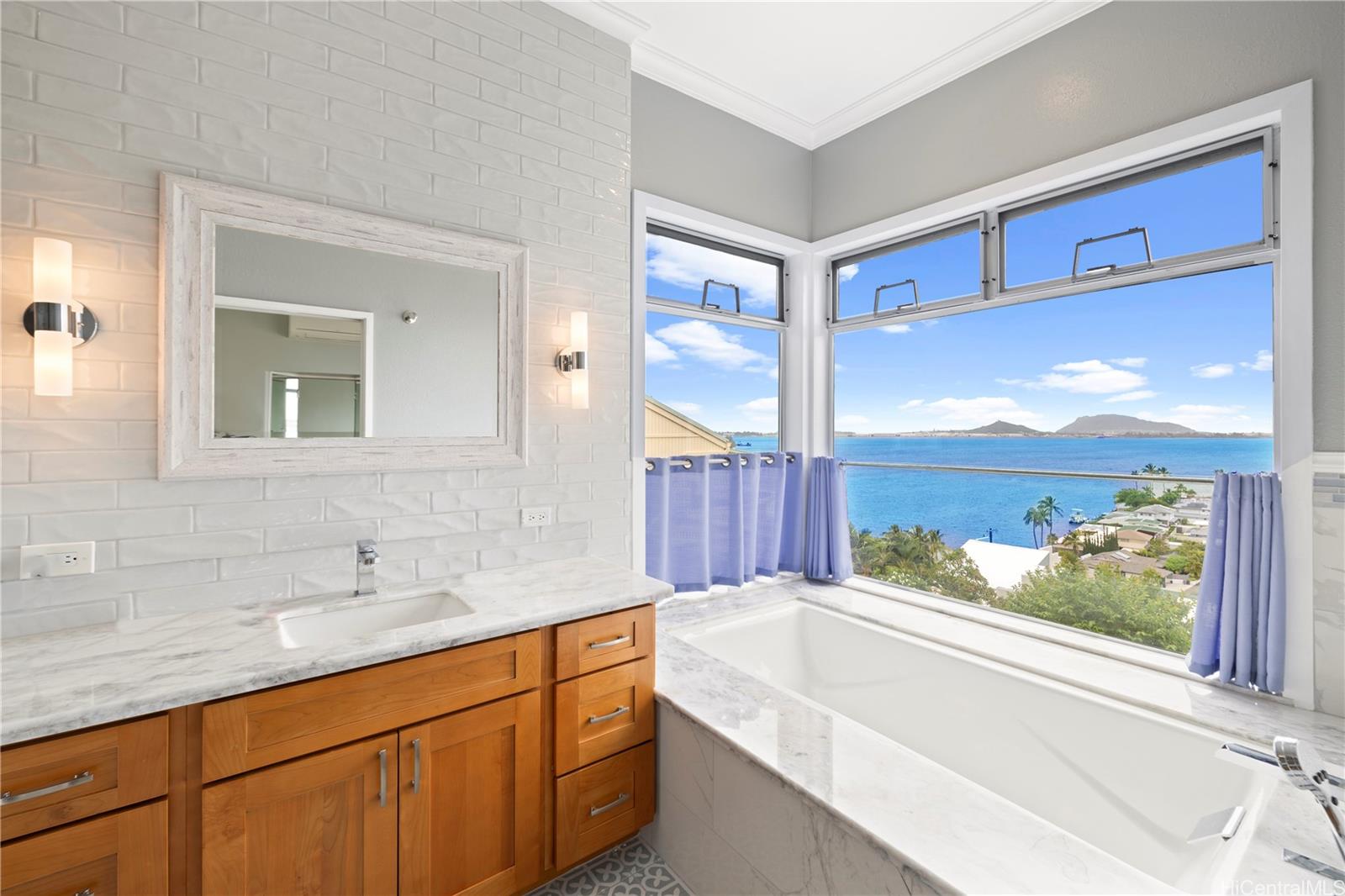 45-081 Lilipuna Road, Unit G Kaneohe, HI 96744 - Photo 16 of 25 a bathroom with a tub sink and mirror