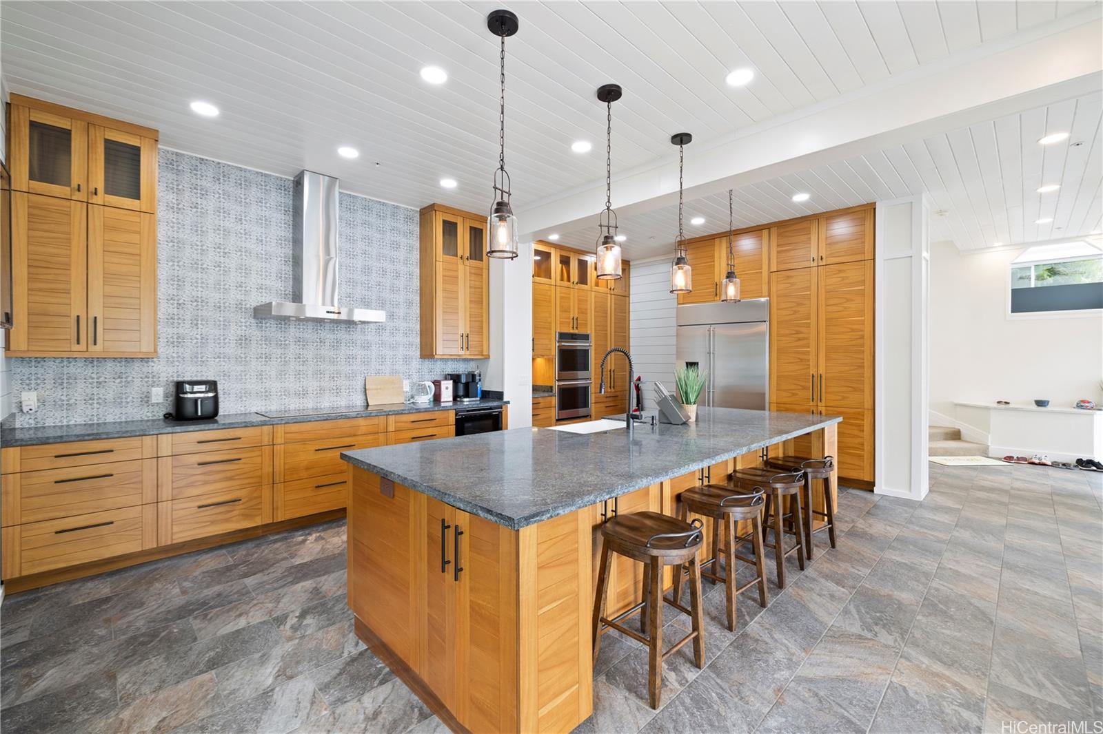 45-081 Lilipuna Road, Unit G Kaneohe, HI 96744 - Photo 7 of 25 a kitchen with stainless steel appliances granite countertop a table chairs sink and stove top oven