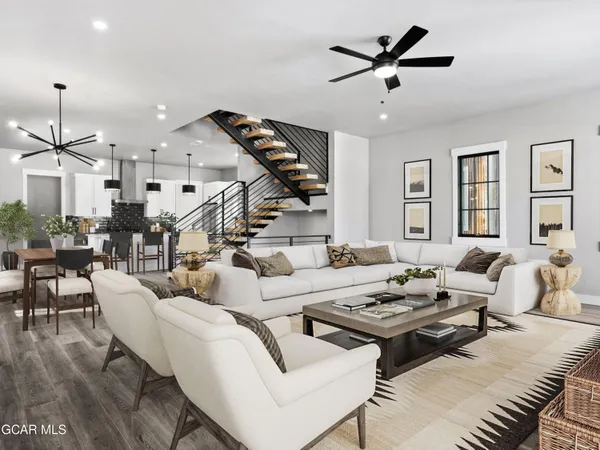 a living room with furniture ceiling fan and a rug