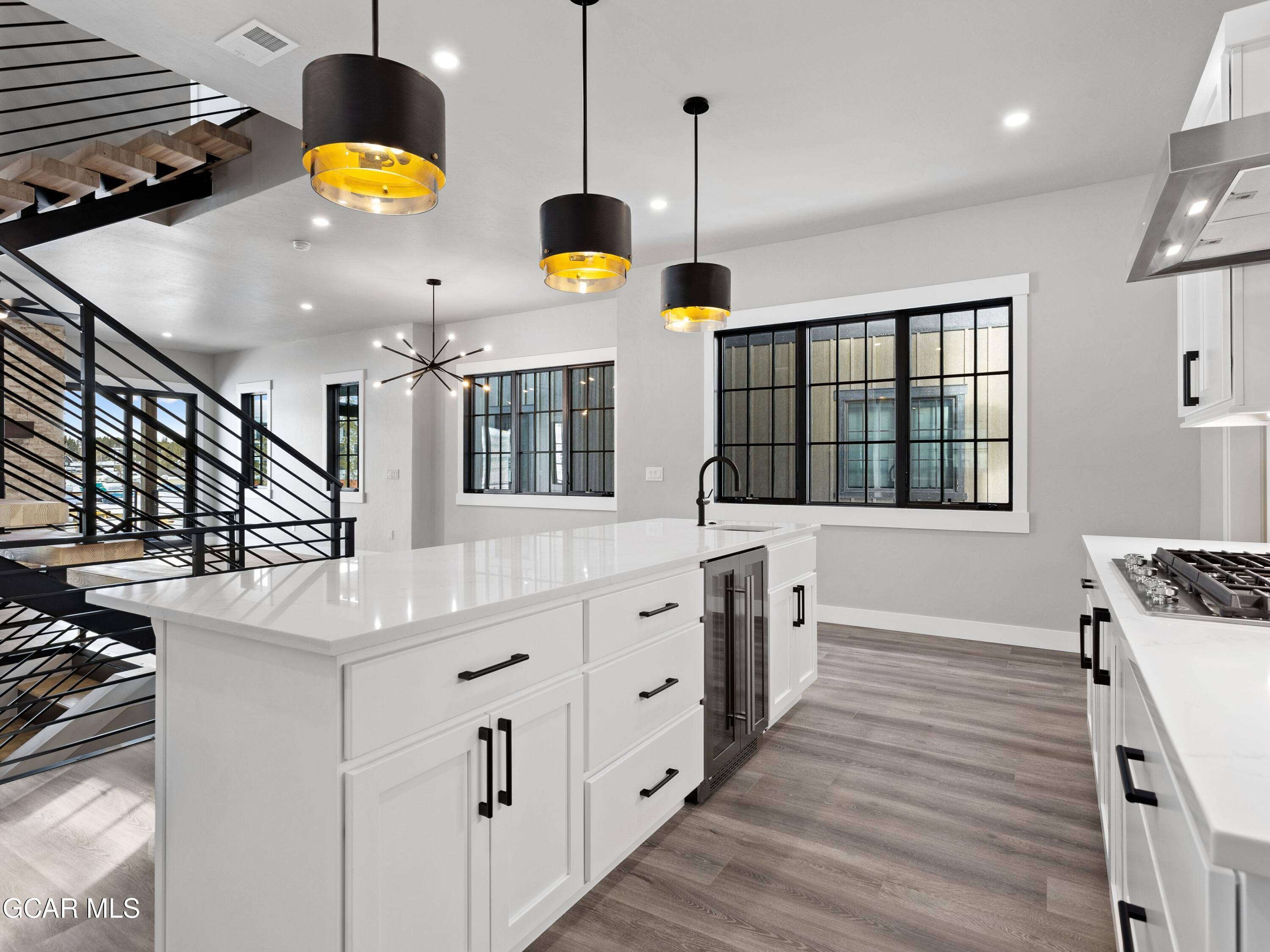 12 Exploration Trail Winter Park, CO 80482 - Photo 6 of 52 a kitchen with stainless steel appliances kitchen island granite countertop a sink and white cabinets with wooden floors