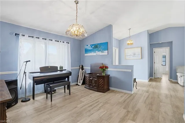 a livingroom with furniture a chandelier and wooden floor