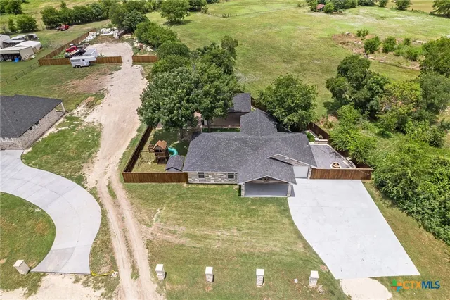 a aerial view of a house with swimming pool and large trees
