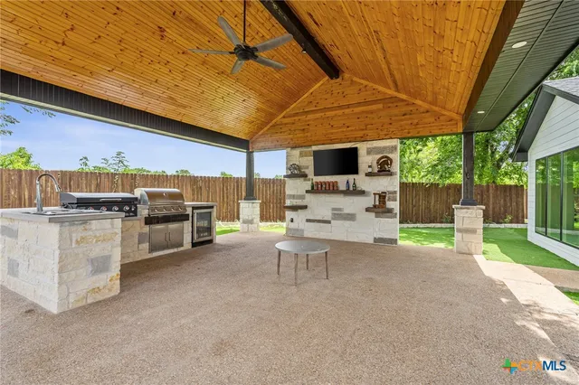 a view of a patio with table and chairs under an umbrella