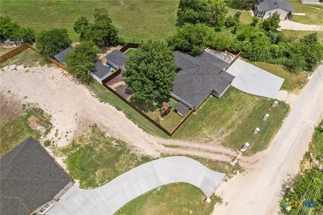 an aerial view of a house with a yard and lake view