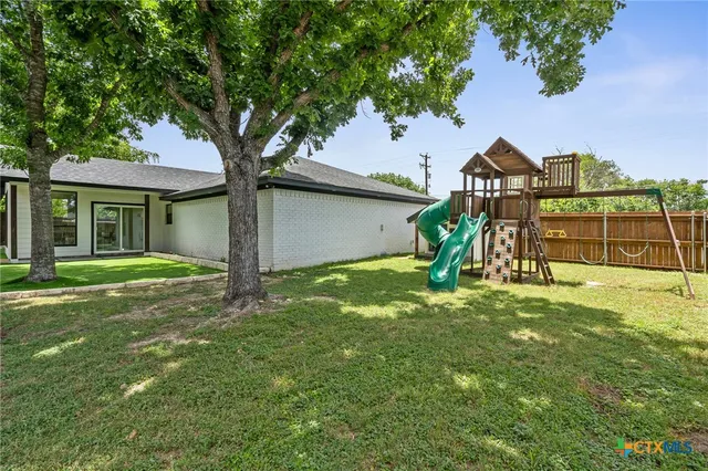 a front view of a house with a yard and trees