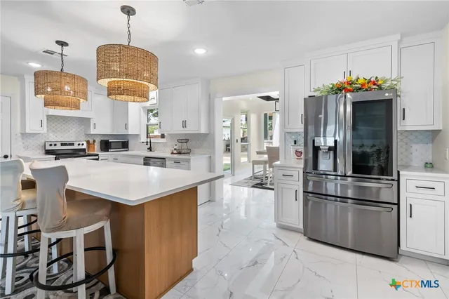 a kitchen with stainless steel appliances granite countertop a sink refrigerator and microwave