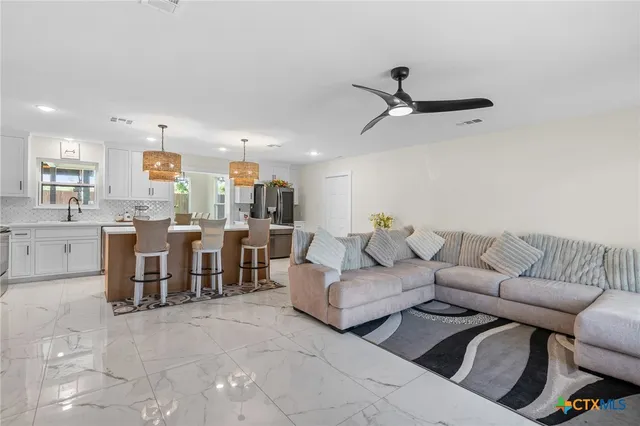 a living room with furniture and kitchen view
