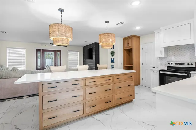 a large kitchen with a center island and stainless steel appliances