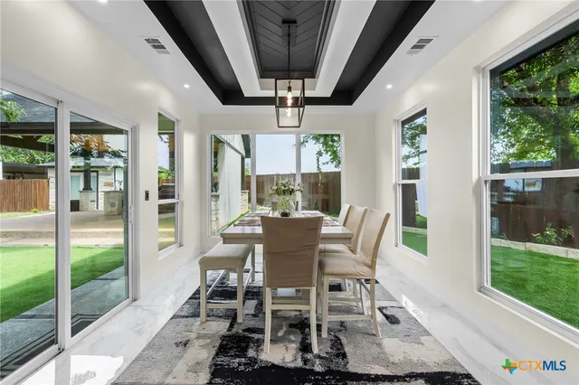 a dining room with furniture a rug and a floor to ceiling window