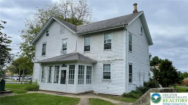 a view of a house with a yard and potted plants