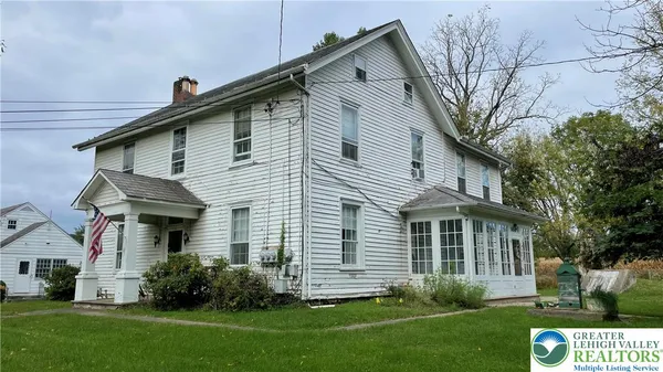 a front view of a house with a yard and trees