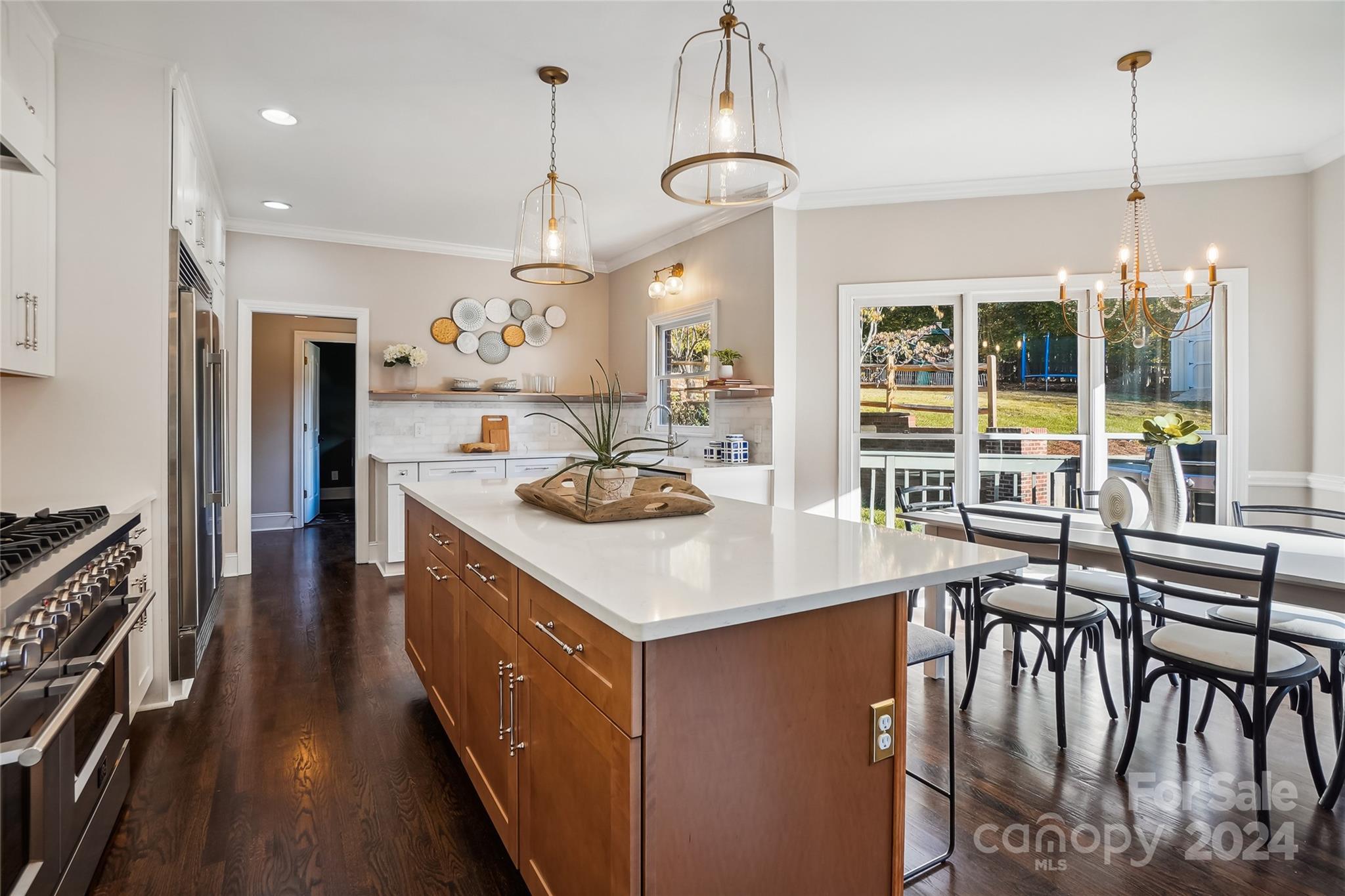 3647 Plantation Road Charlotte, NC 28270 - Photo 3 of 36 a kitchen with a table chairs stove and cabinets