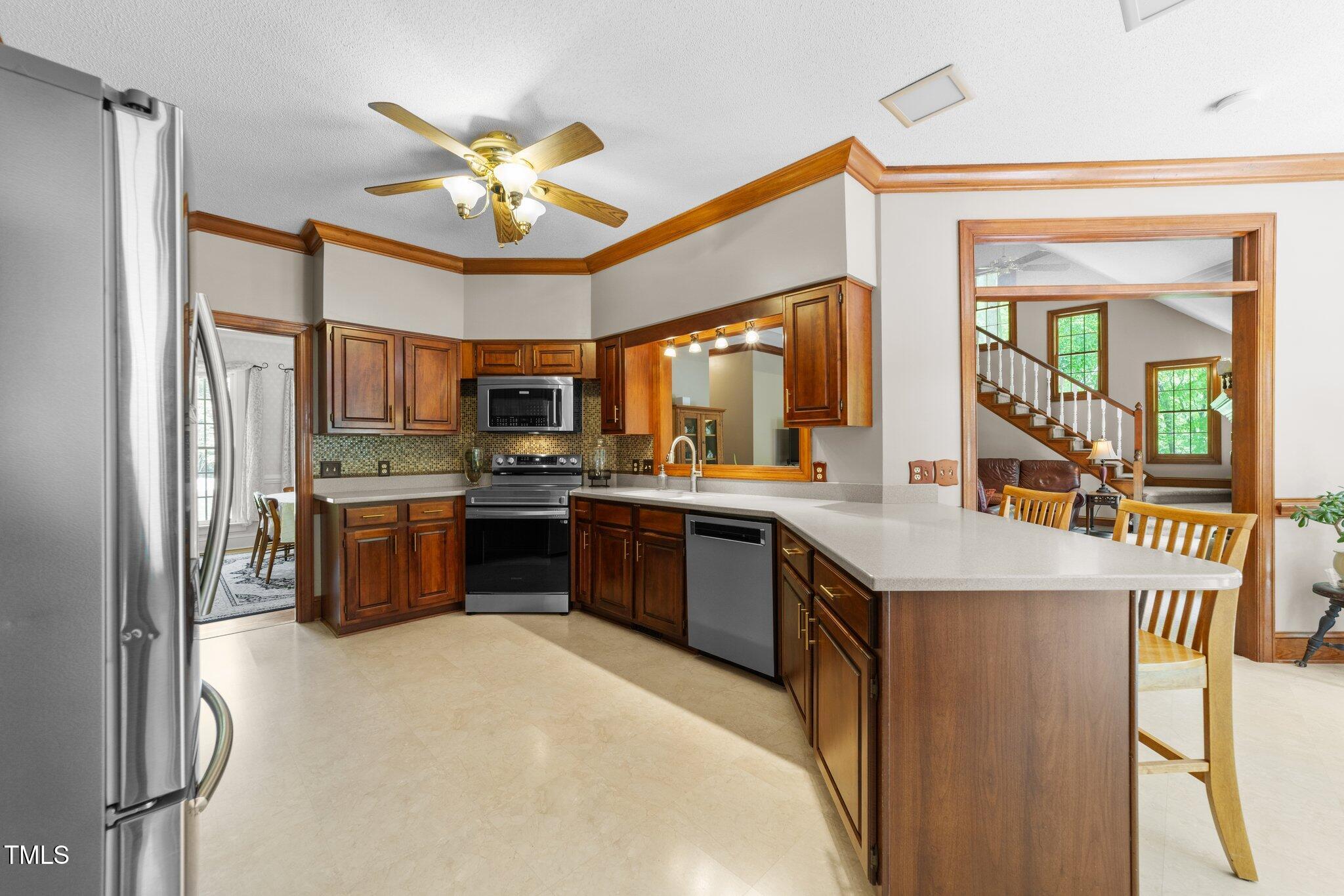 12200 Glenlivet Way Raleigh, NC 27613 - Photo 10 of 51 a kitchen with stainless steel appliances granite countertop a refrigerator a sink dishwasher a stove and a dining table with wooden floor