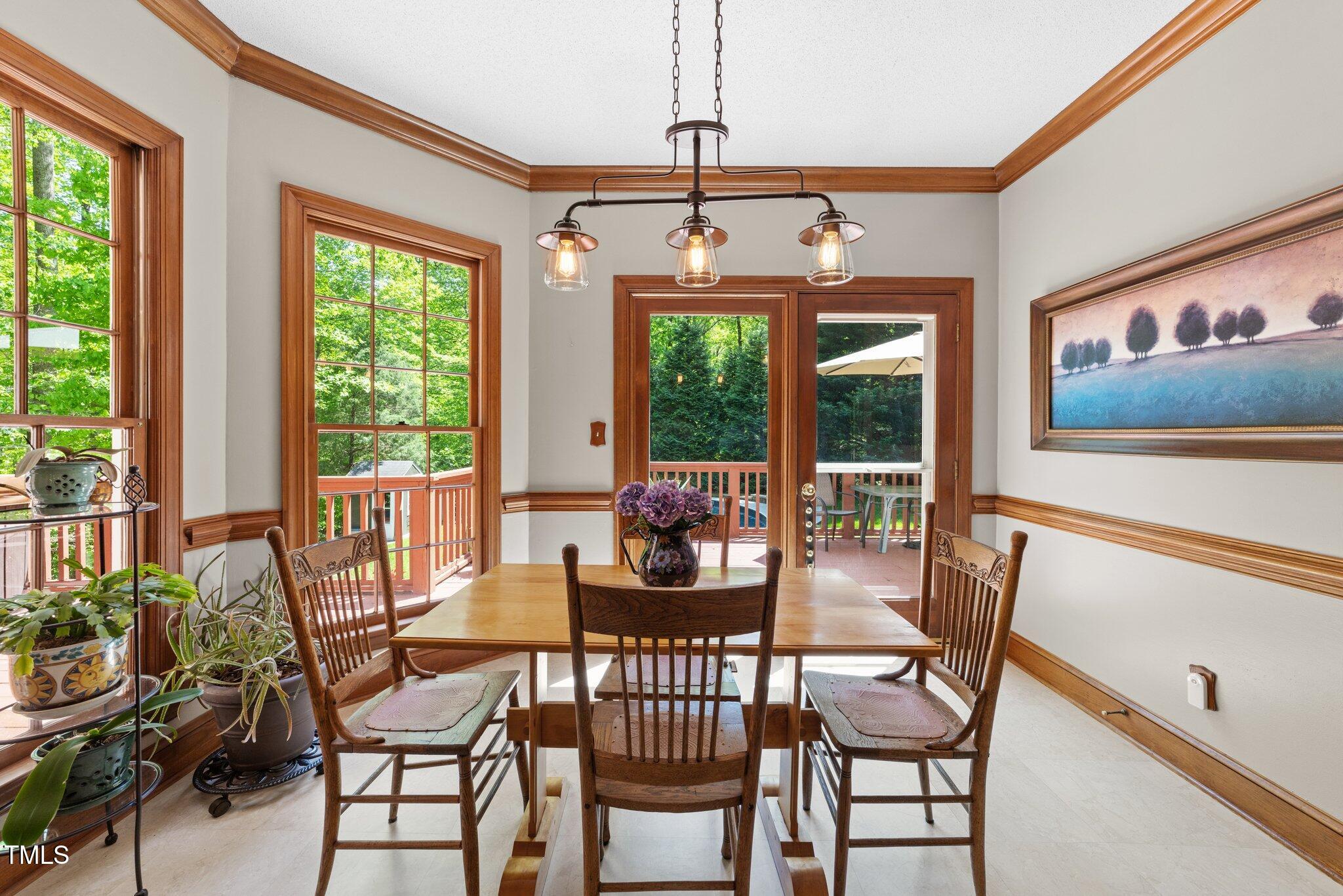 12200 Glenlivet Way Raleigh, NC 27613 - Photo 13 of 51 a dining room with furniture a chandelier and wooden floor