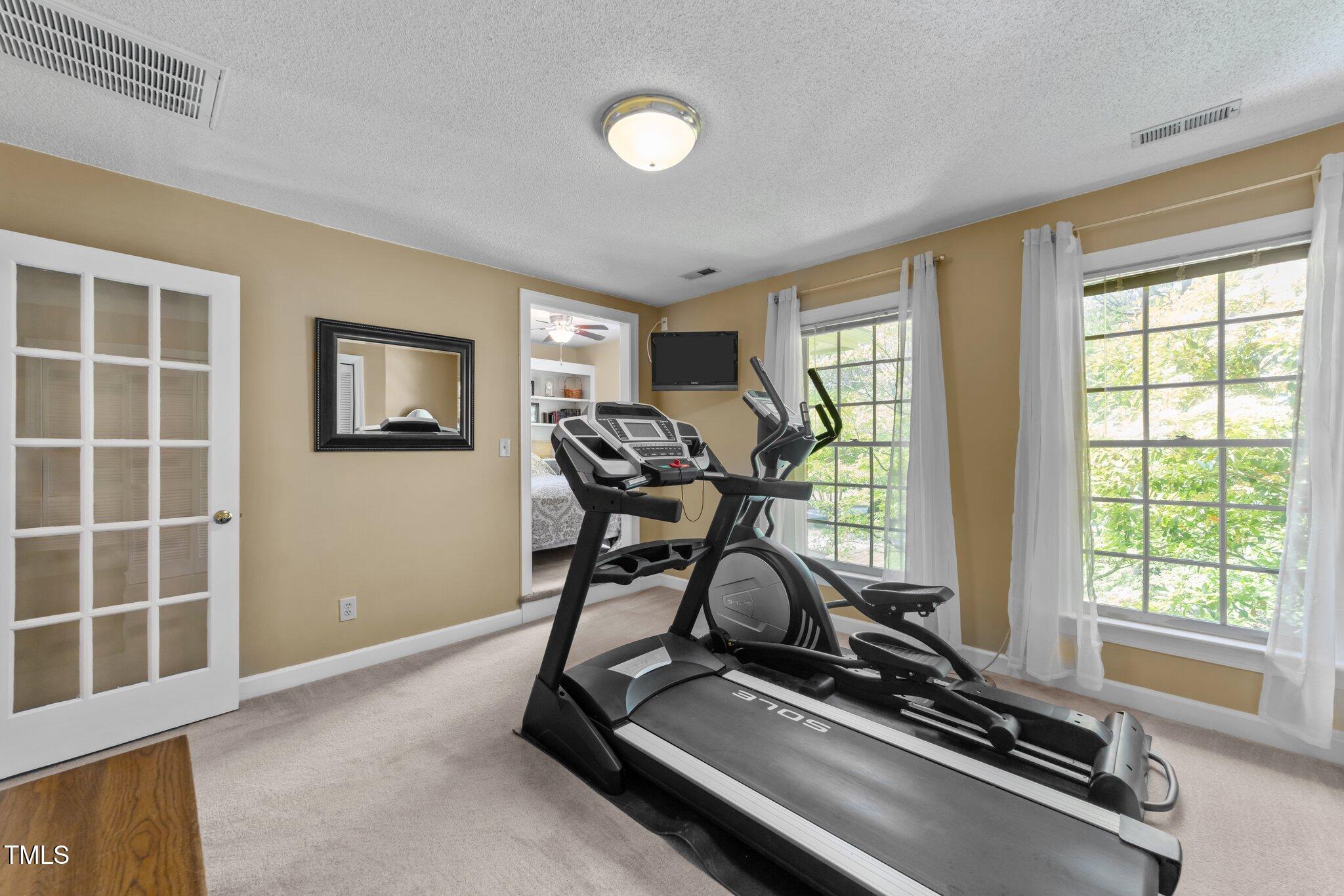 12200 Glenlivet Way Raleigh, NC 27613 - Photo 18 of 51 a room with gym equipment and a large window