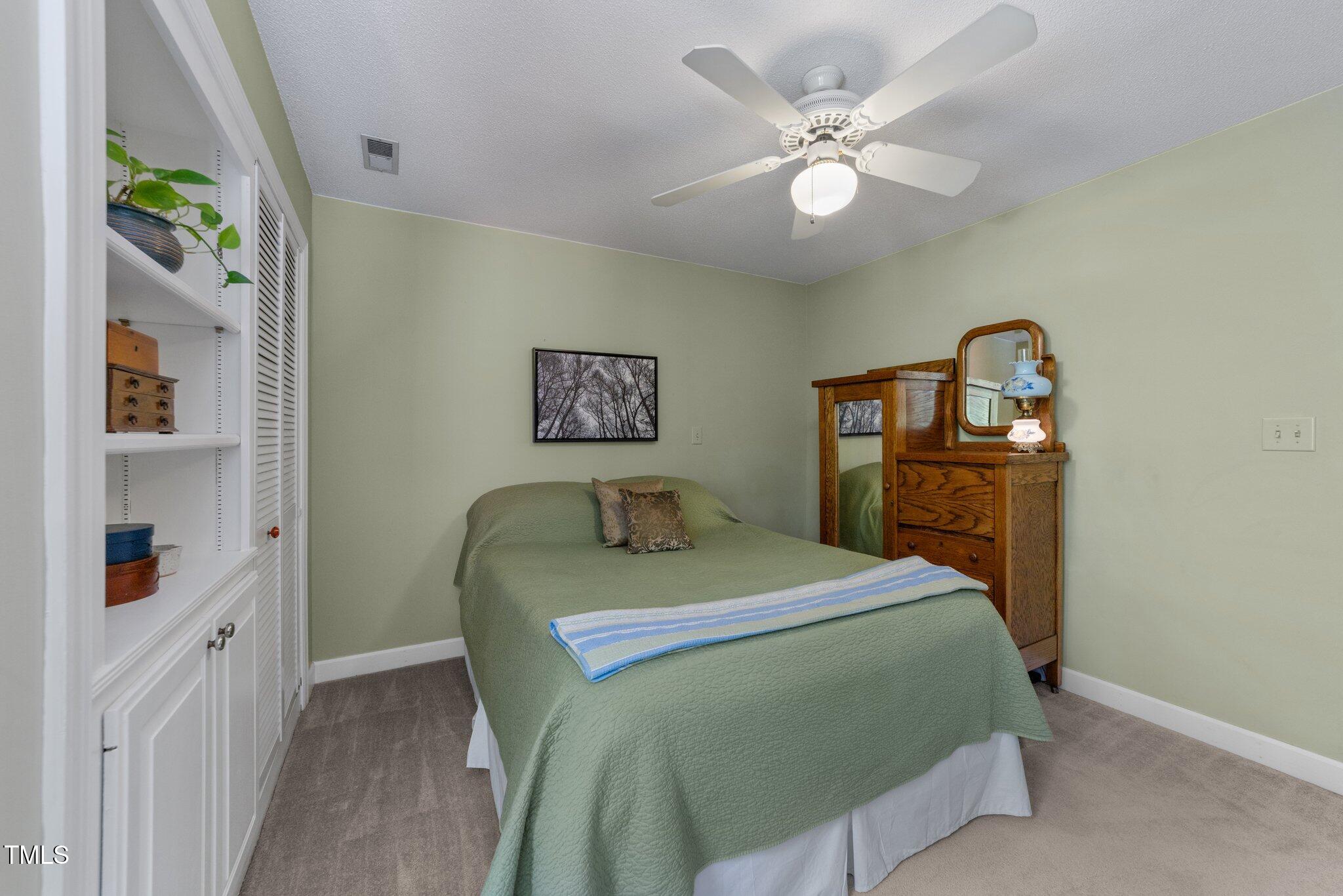 12200 Glenlivet Way Raleigh, NC 27613 - Photo 23 of 51 a bedroom with a bed and a chandelier
