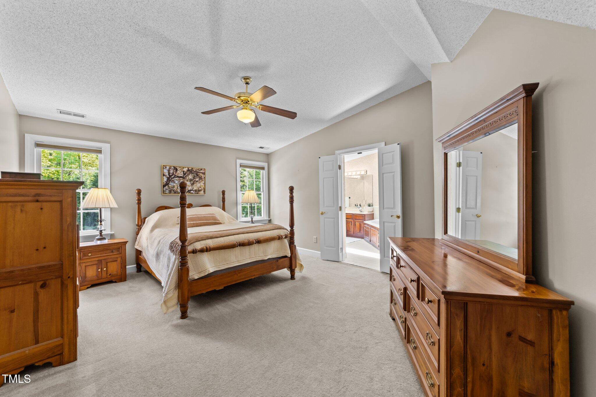12200 Glenlivet Way Raleigh, NC 27613 - Photo 26 of 51 a bedroom with a bed and a chandelier