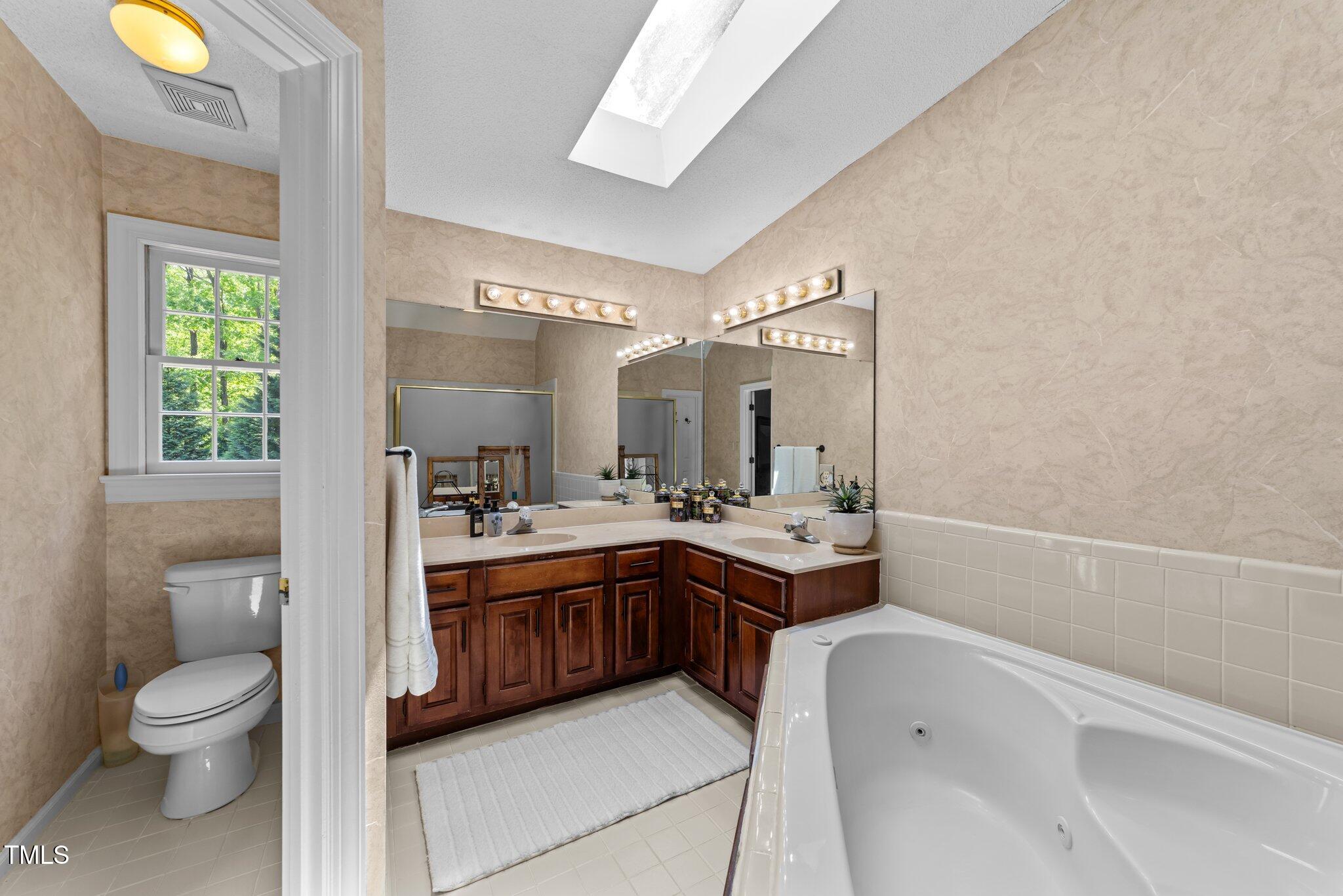 12200 Glenlivet Way Raleigh, NC 27613 - Photo 29 of 51 a bathroom with a granite countertop sink a toilet and mirror