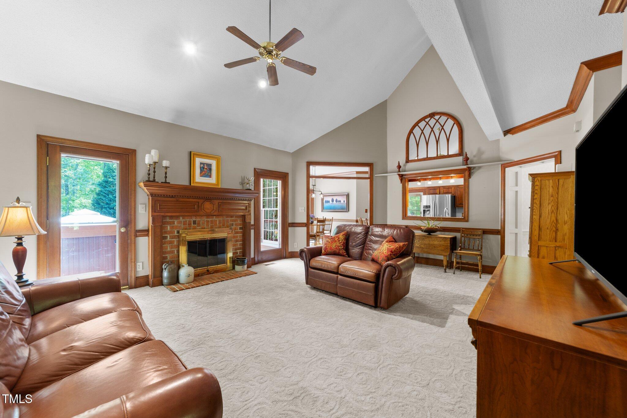 12200 Glenlivet Way Raleigh, NC 27613 - Photo 7 of 51 a living room with furniture a fireplace and a flat screen tv