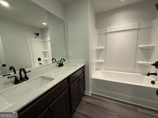 a bathroom with a tub a sink and mirror