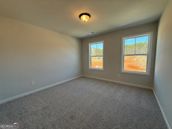 a view of an empty room with a window and bathroom