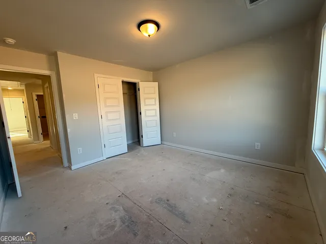 an empty room with closet area and natural light