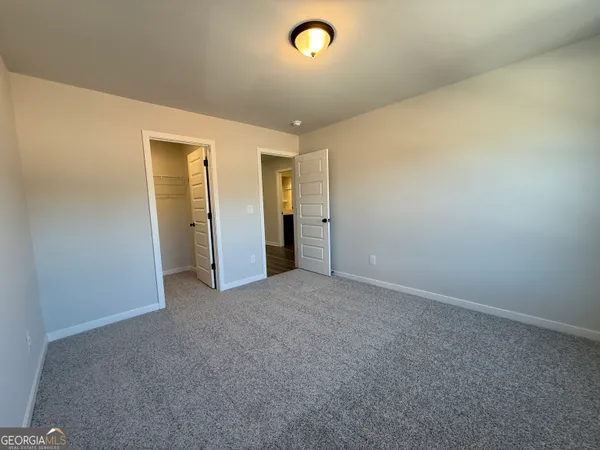 an empty room with closet and windows