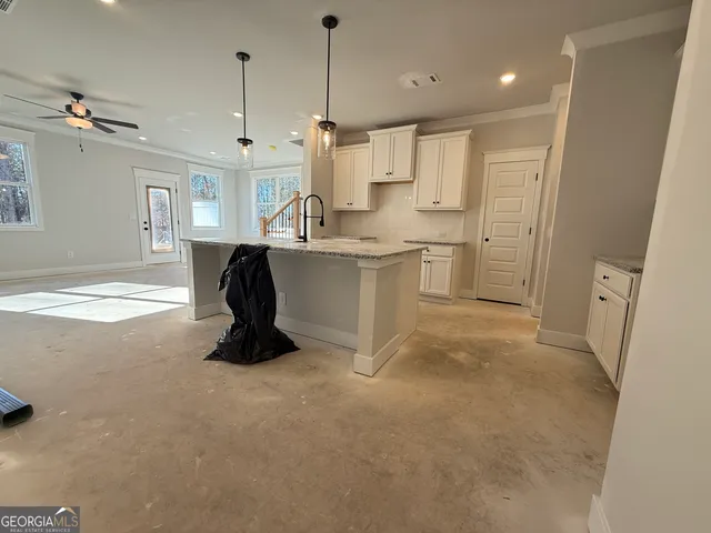 a large kitchen with stainless steel appliances granite countertop a refrigerator a sink and a stove