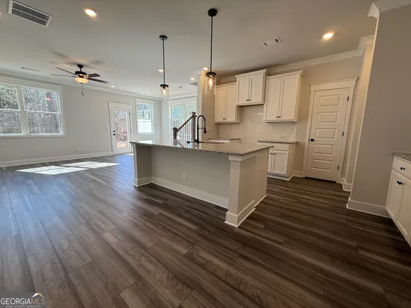 a kitchen with kitchen island a sink wooden floor and white appliances