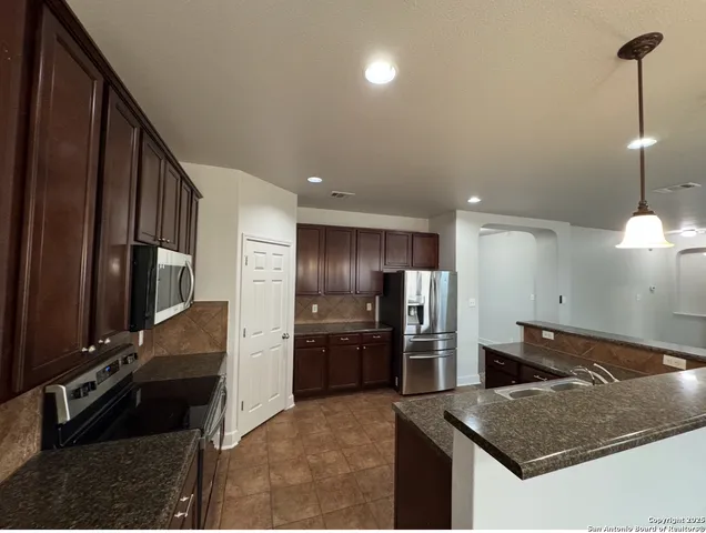a kitchen with stainless steel appliances granite countertop a refrigerator and a sink