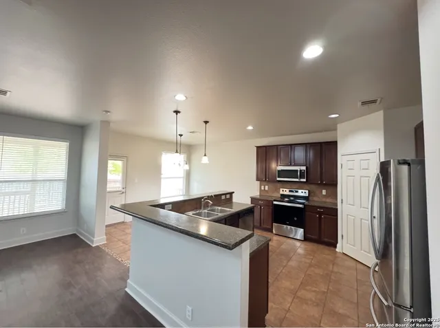 a kitchen with stainless steel appliances granite countertop a sink stove and refrigerator